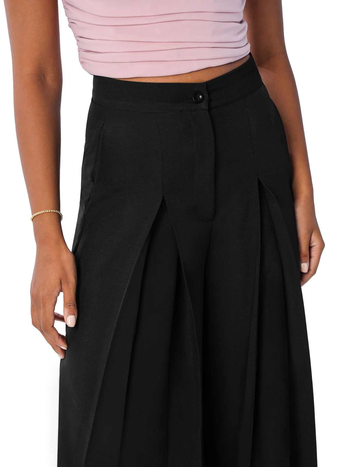 Close view of the black trouser waistband, button and inverted pleats