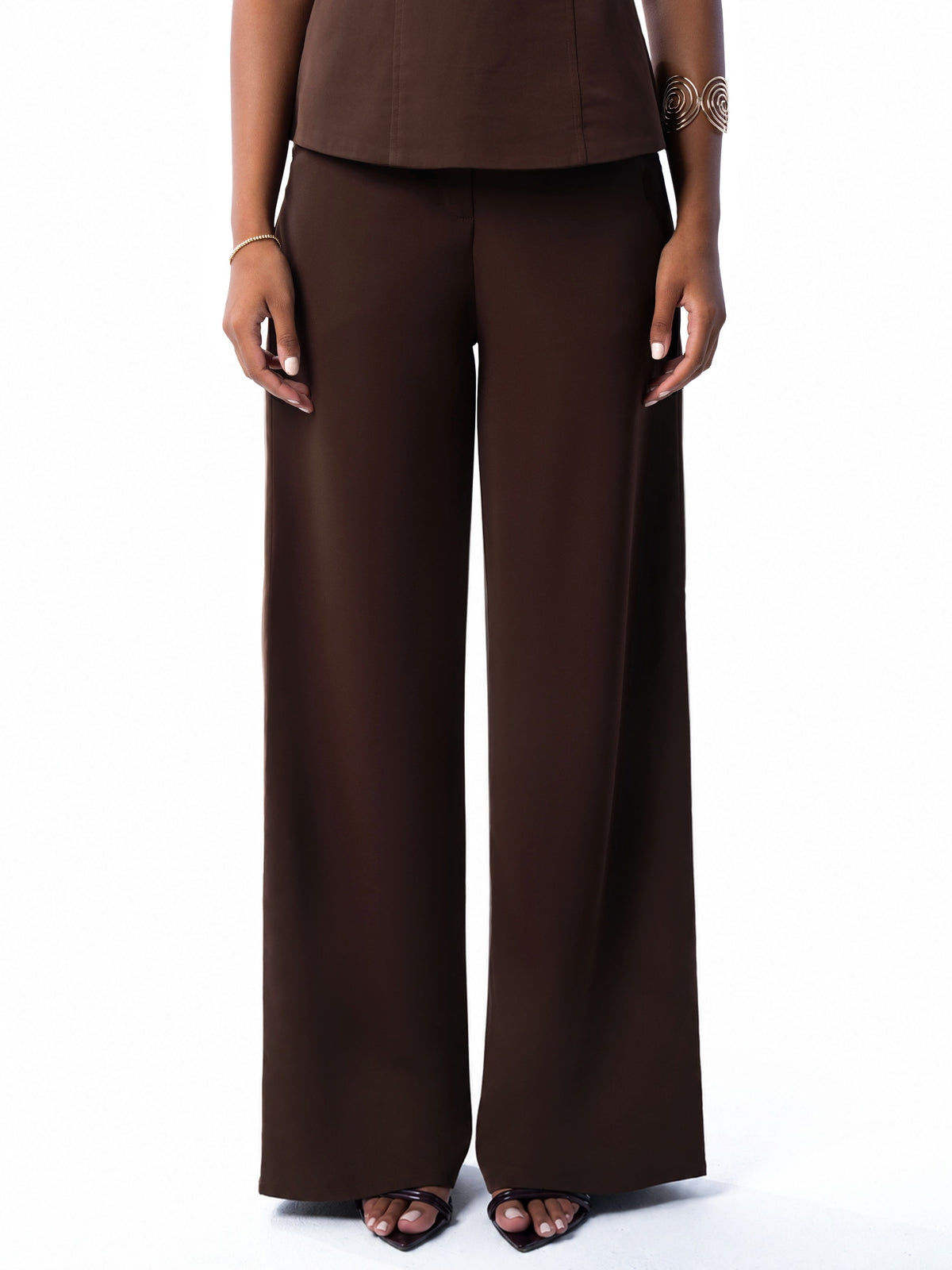 Close view of the brown wide-leg trouser waistband and drape